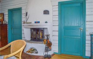 Väsby的住宿－Pet Friendly Home In R With Lake View，客厅设有蓝色门和壁炉