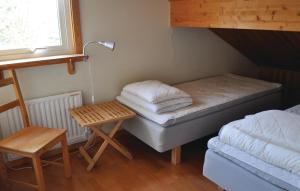 a small room with a bed and a lamp and a table at 4 Bedroom Gorgeous Home In Frseke in Fröseke