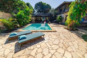 una piscina con 2 tumbonas y un cisne en Morada do Sol Guest House, en Búzios