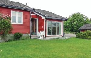 a red house with a lawn in front of it at Nice Studio In Gravdal With Kitchen in Gravdal