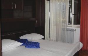 een bed met 2 kussens in een kamer met een raam bij 2 Bedroom Amazing Apartment In Rabac in Rabac
