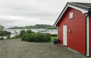 a red building with a view of a body of water at Nice Studio In Gravdal With Kitchen in Gravdal