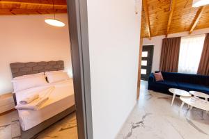 a bedroom with a bed and a blue couch at Santa Oliva Suites in Ksamil