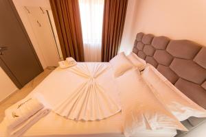 a bedroom with a large bed with a headboard at Santa Oliva Suites in Ksamil