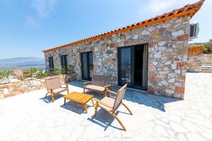 a patio with chairs and a table and a building at Santa Oliva Suites in Ksamil