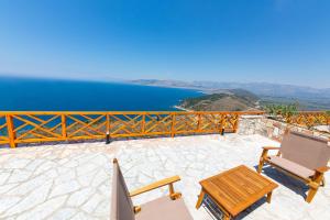 a patio with a table and chairs and the water at Santa Oliva Suites in Ksamil