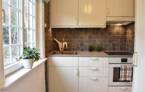 a kitchen with white cabinets and a sink at Nice Home In Hllviken With 2 Bedrooms in Höllviken