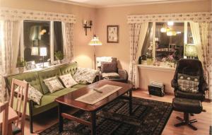 a living room with a green couch and a table at 5 Bedroom Lovely Home In Seim in Seim
