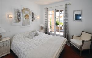 ein Schlafzimmer mit einem Bett und einem Stuhl und einem Fenster in der Unterkunft Cozy Home In Les Issambres in Les Issambres + 20 Fotos