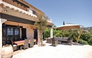 eine Außenterrasse mit einem Tisch und einem Sonnenschirm in der Unterkunft Cozy Home In Les Issambres in Les Issambres