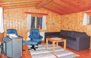 a living room with a couch and chairs and a tv at 2 Bedroom Awesome Home In Älvdalen in Blyberg