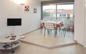 a dining room with a table and chairs and a window at Nice Apartment In Gruissan With Kitchen in Gruissan