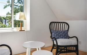 a black chair with a blue pillow sitting next to a table at Amazing Apartment In Glemmingebro in Glemminge