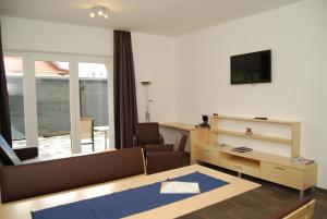 a living room with a table and a desk with a television at Haus Schraberger in Schladming