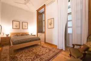 um quarto com uma cama, uma cadeira e uma janela em Classic Lisbon Downtown Apartment em Lisboa