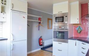 a kitchen with white cabinets and a stove at Nice Home In Romakloster With 3 Bedrooms And Wifi in Romakloster