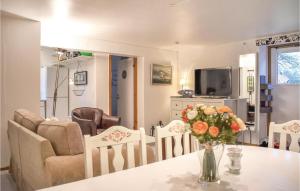 una sala de estar con una mesa con un jarrón de flores en Cozy Home In Hllviken With Wifi en Höllviken