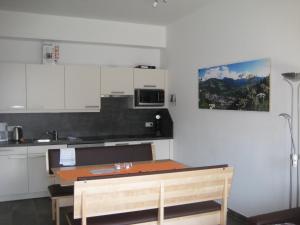 a kitchen with a table and a kitchen with white cabinets at Haus Schraberger in Schladming