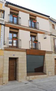 a building with two balconies and a garage at Apartamentos Turísticos Mirablanc in Valjunquera