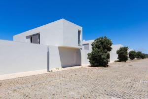 una casa blanca en una calle adoquinada en Santa Cruz Ocean View Villa, en Bombardeira