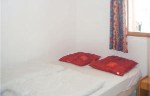 two red pillows sitting on a bed in a room at Beautiful Home In Teyssieres With 2 Bedrooms And Outdoor Swimming Pool in Teyssières