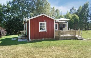 um barracão vermelho com uma cerca no quintal em Nice Home In Sjtofta With Kitchen em Sjötofta