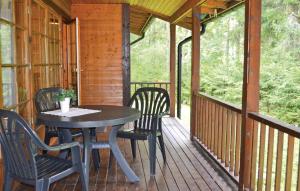 a table and chairs on the porch of a cabin at Lovely Home In Gislaved With Lake View in Våthult