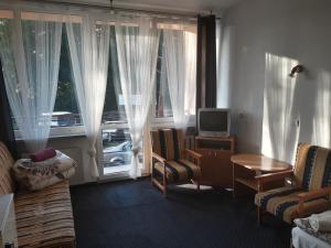 a living room with a couch and a tv and window at Prima in Krynica Morska