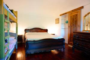 a bedroom with a bed and a bunk bed with a dresser at B&BTorre Cives in Vidracco
