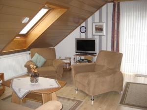 uma sala de estar com duas cadeiras e uma televisão em Ferienwohnung in der Vulkaneifel em Ulmen