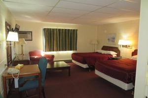 Habitación de hotel con 2 camas y sala de estar. en Grand Inn Fargo en Fargo
