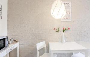 a white dining room with a white table and a vase with flowers at Appartement 1 - De Eekhof in Hindeloopen