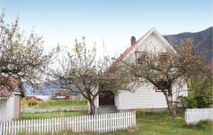 a white house with a white fence and trees at Solhaug in Fresvik