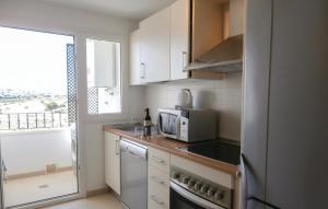 a small kitchen with a microwave and a window at Amazing Apartment In Sucina With 2 Bedrooms, Wifi And Outdoor Swimming Pool in Sucina