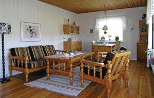 een woonkamer met een houten tafel en stoelen bij Amazing Home In Smlandsstenar With Kitchen in Åtterås