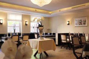 a dining room with a table with a vase of flowers on it at Hotel Restaurant Am Kring in Vreden
