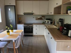 a kitchen with white cabinets and a table and a stove at Happy Family in Skala Kallirakhis