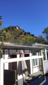 MiyunにあるThe Great Wall Box House - Beijingの傘付きのパティオ、家