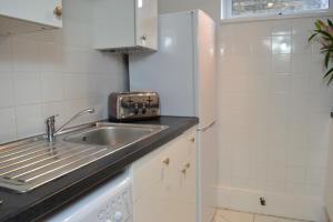 a small kitchen with a sink and a refrigerator at Epicsa - Family & Corporate Stay MEWS APARTMENTS with FREE parking in Cambridge +129 photos