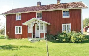 une maison rouge avec une porte blanche dans une cour dans l'établissement 2 Bedroom Cozy Home In Bredaryd, à Sporda