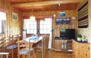 a dining room with a table and a television at Thorleifsbuskogheim in Vevle