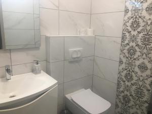 a white bathroom with a toilet and a sink at Royal Apartments & Rooms in Zagreb