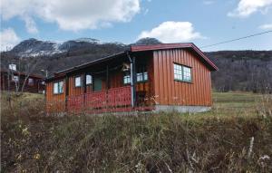 a red cabin in the middle of a field at Thorleifsbuskogheim in Vevle