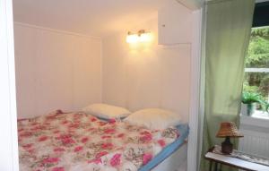 a bedroom with a bed with flowers on it at 2 Bedroom Lovely Home In Osby in Hästveda