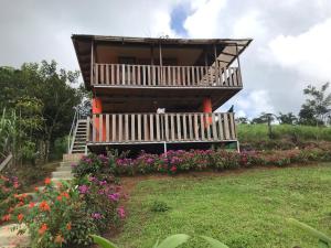 une maison avec balcon et quelques fleurs dans l'établissement Cabaña La Piña, à San Rafael