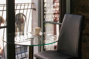 a glass table and a chair with a coffee cup on it at Le Petit Hôtel Vieux-Montréal - Saint-Paul by Gray Collection in Montreal