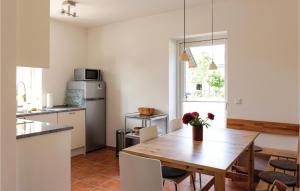 a kitchen with a wooden table and a dining room at Lovely Home In Gammelby With Kitchen in Gammelby