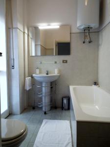 y baño con lavabo, bañera y aseo. en Lacaralele Apartment, en Milán