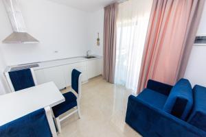 a living room with a table and blue chairs at Santa Oliva Suites in Ksamil