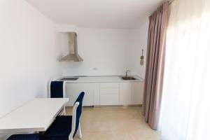 a kitchen with a table and a sink and a table and chairs at Santa Oliva Suites in Ksamil